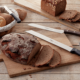 Krustenbrot und zwei Brotmesser von Emil Schmidt auf einem Schneidebrett aus Holz